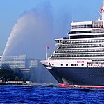 Vista esterna del Maritim Hotel Kiel, in primo piano la nave da crociera Queen Elizabeth e un rimorchiatore sull'acqua.