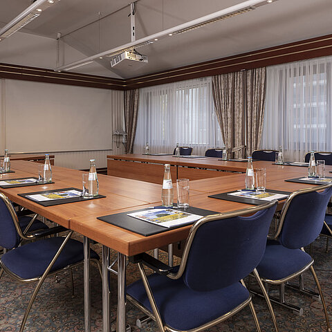 Sala conferenze moderna al Maritim Hotel Magdeburg con disposizione a U, luce naturale e attrezzature di alta qualità.