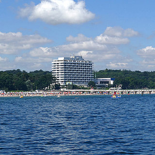 Maritim Seehotel Timmendorfer Strand, jetée et drapeaux colorés depuis un bateau par temps ensoleillé.