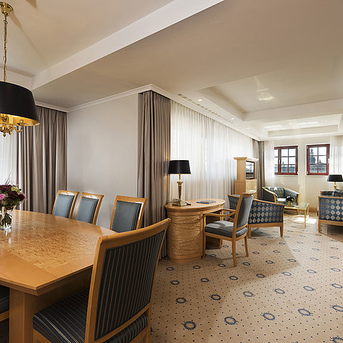 Suite Executive spaziosa al Maritim Hotel Dresden con elegante tavolo da pranzo, area salotto confortevole e vista sulla citt