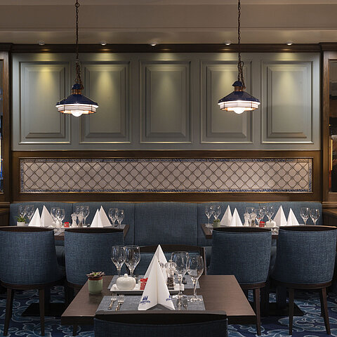Elegante ristorante dell'hotel Maritim Darmstadt con tavoli apparecchiati, lampade eleganti e atmosfera accogliente.