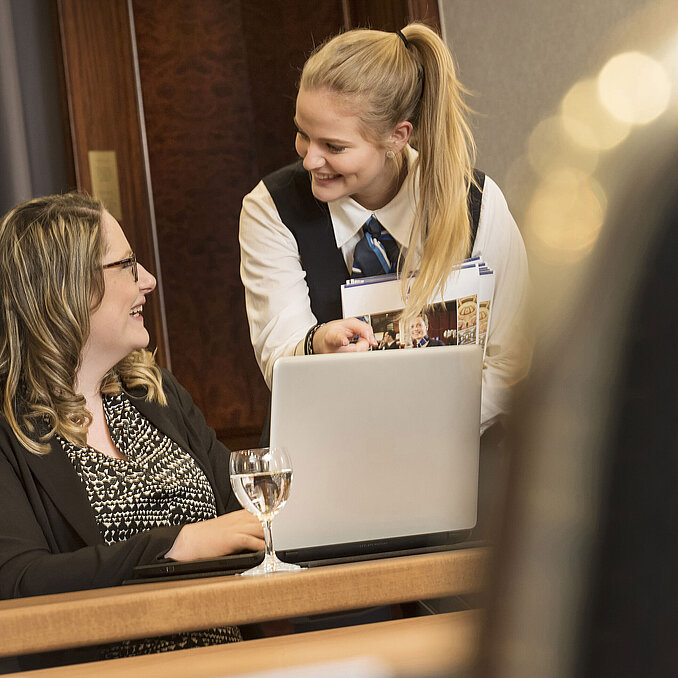 Una empleada del Hotel Maritim Bonn asiste a una participante durante una reunión en el salón Rheinaue.
