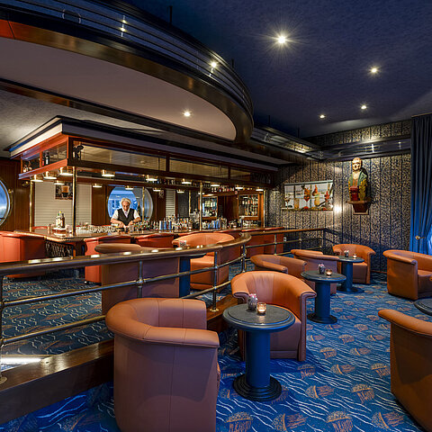 Bar elegante con poltrone accoglienti e decorazioni nautiche al Maritim Seehotel Timmendorfer Strand.
