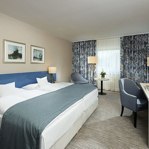 Camera Superior al Maritim Hotel Bonn con design elegante, letti comodi, scrivania moderna e area salotto confortevole.