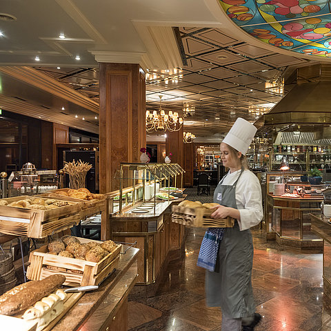 Buffet de petit déjeuner à l'hôtel Maritim avec des petits pains frais, du pain et une sélection de plats, servi par une chef