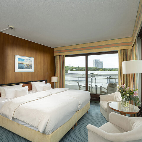 Spacieuse suite familiale au Maritim Seehotel Timmendorfer Strand avec balcon, vue sur mer et coin salon.