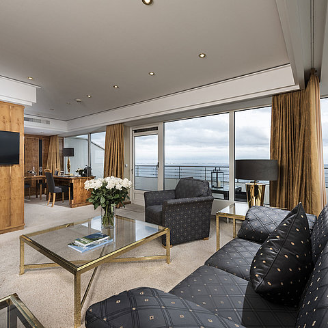  Salon de penthouse avec vue sur la mer, mobilier élégant et grande baie vitrée au Maritim Seehotel Timmendorfer Strand.