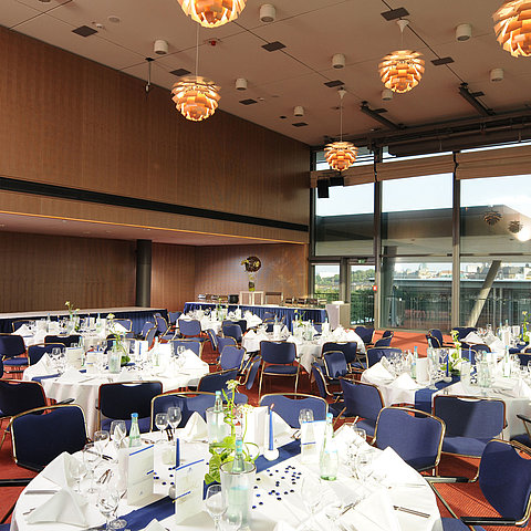 Salle d'événements élégante de l'hôtel Maritim de Dresde avec des tables festives et vue sur la ville.