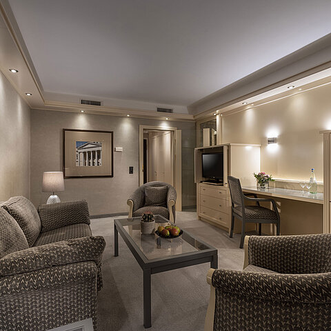  Elegante suite nel Maritim Hotel Darmstadt con un'accogliente area salotto, un'illuminazione elegante e una scrivania.
