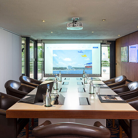 Salle de conférence Salon Fulda à l'hôtel Maritim Timmendorfer Strand avec table de conférence,fauteuils en cuir et projecteur