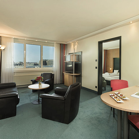 Soggiorno della Superior Suite al Maritim proArte Hotel Berlin con area salotto e vista dalla finestra.