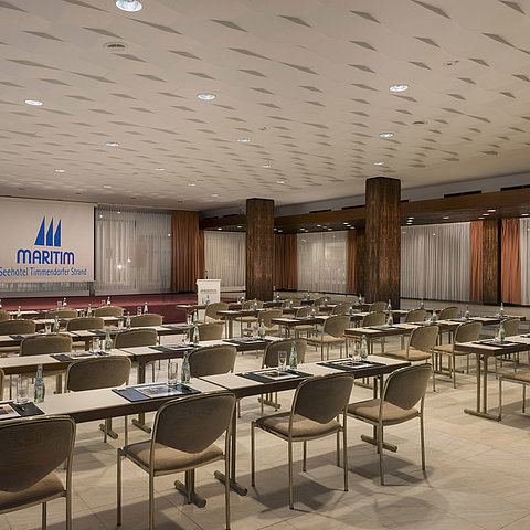 Salle de conférence « Bremen » au Maritim Seehotel Timmendorfer Strand avec rangées de sièges et scène.