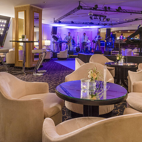 Elegante area bar con band dal vivo, illuminazione d'atmosfera e comodi posti a sedere per gli ospiti.