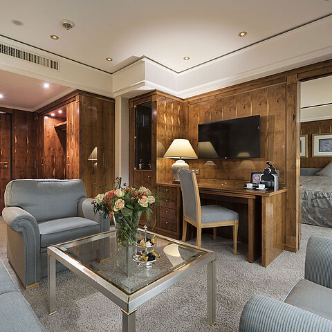Suite penthouse avec salon, meubles en bois, bureau et vue sur la chambre au Maritim Seehotel Timmendorfer Strand.