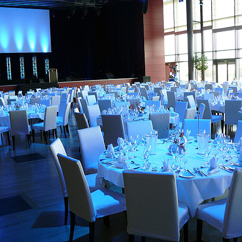 Sala de eventos con iluminación ambiental en el Maritim Hotel Dresden con mesas elegantemente dispuestas.
