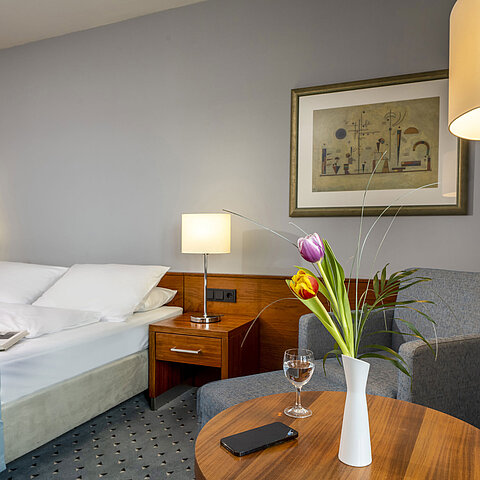 Camera doppia comfort al Maritim Hotel Darmstadt con arredi eleganti, area salotto accogliente e accenti moderni.