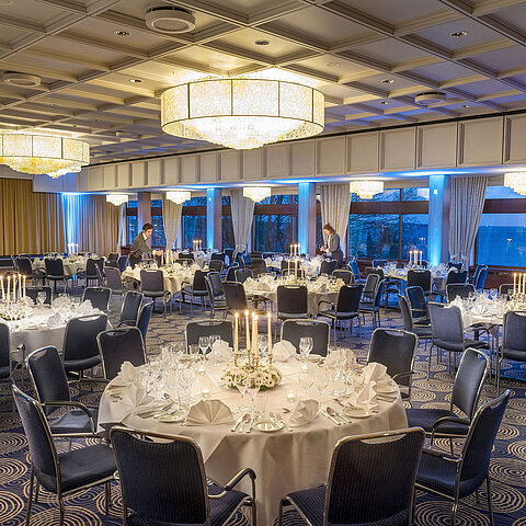 Salle Maritim de l'hôtel Maritim de Kiel, tables festives éclairées aux bougies, ambiance élégante, le personnel prépare l'événement.