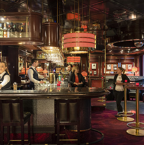  Les clients profitent de boissons et de l'atmosphère détendue dans la bar élégant de l'hôtel Maritim Bremen.