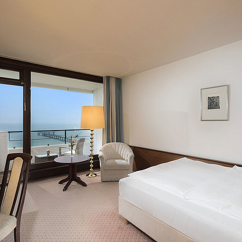 Chambre simple au Maritim Seehotel Timmendorfer Strand avec vue mer, balcon et coin salon confortable.